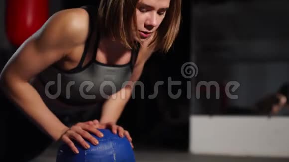 一个深黑肤色的运动员在健身房的大砍刀上做俯卧撑把秒表放在手机上拳击训练视频的预览图