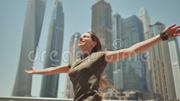 一个快乐的女孩在迪拜的摩天大楼背景下迪拜码头视频的预览图