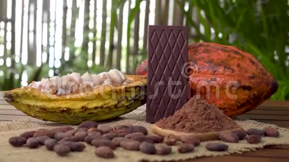 木制桌子上的苦巧克力棒生可可水果可可豆可可粉视频的预览图