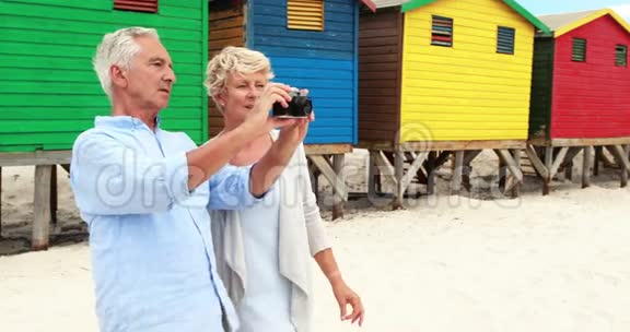 年长夫妇在海滩上点击相机拍照视频的预览图