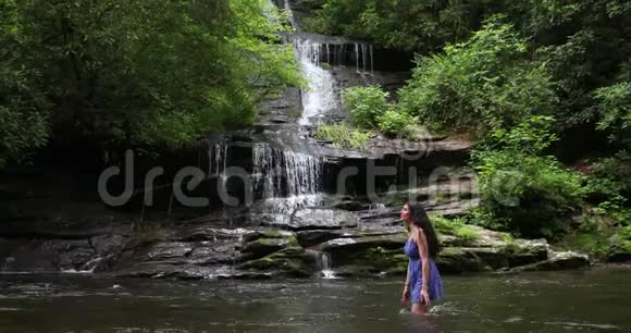 美丽的女士在瀑布旁泼水视频的预览图