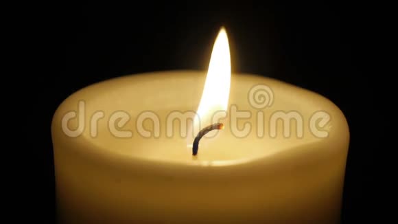 在黑色背景上隔离燃烧蜡烛的特写视频的预览图