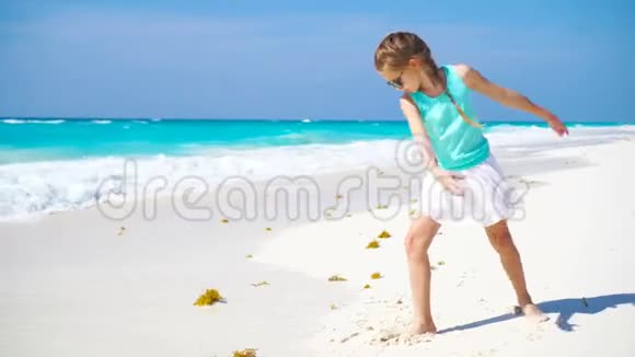 可爱的小女孩在海滩上玩得很开心活泼好动的孩子在海边跳舞视频的预览图