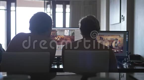 背面的两个年轻男子朋友裸胸在家分享信息和使用电脑工作视频的预览图
