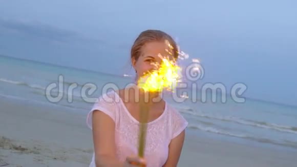 在海滩上微笑的年轻女子在夕阳下慢悠悠地闪烁着光芒视频的预览图