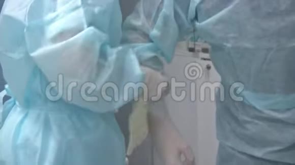 外科医生戴上无菌橡胶手套在背景灯上进行复杂的外科手术视频的预览图