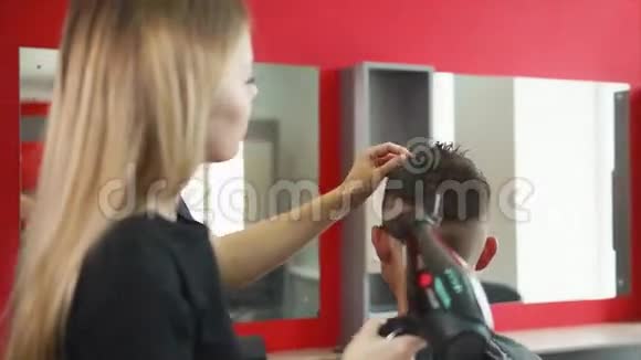 女理发师整理发型她给顾客烘干吹风机视频的预览图