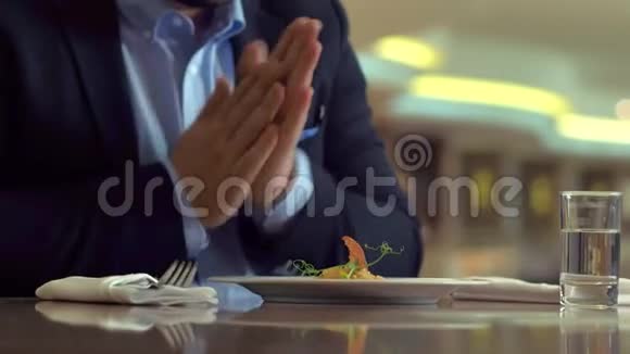 饥饿的人在吃饭前搓手拿餐巾在手机上拍照食物视频的预览图
