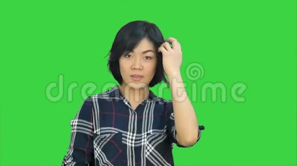 年轻的亚洲女人微笑着在绿色屏幕上跳舞Chroma键视频的预览图