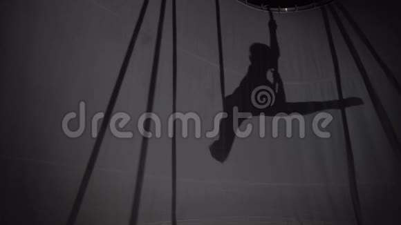 一个女孩轻轻地挂在吊床上做瑜伽的剪影视频的预览图