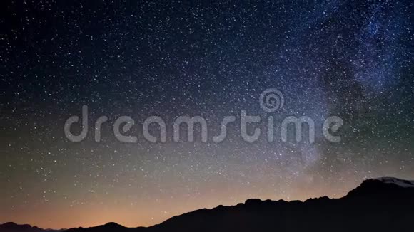 在银河系和阿尔卑斯山上空旋转的星空中流星与星尘一起爆发视频的预览图