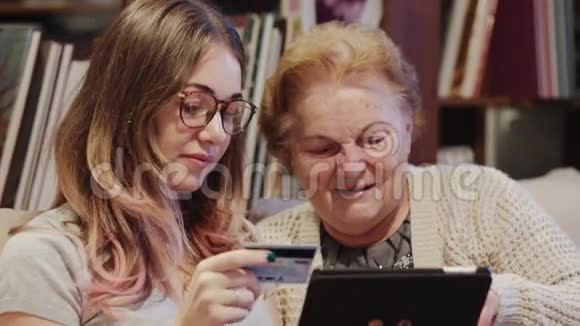 一位性格开朗的年轻女士教她的祖母如何使用平板电脑视频的预览图