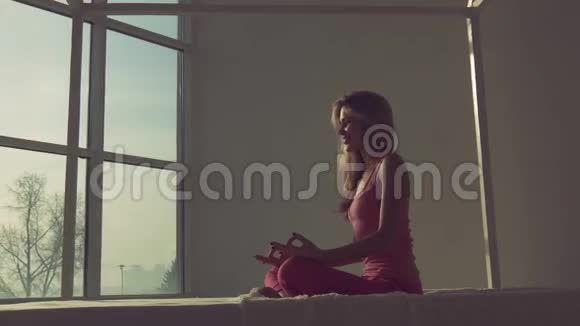 一幅美丽的金发女子坐在莲花的位置前倾的画像视频的预览图
