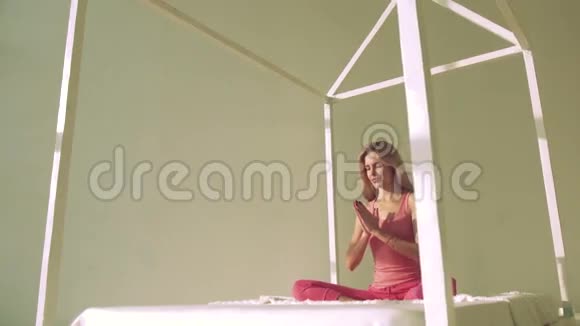 金发美女在床上摆瑜伽姿势视频的预览图