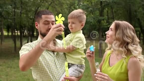 一家人带着一个儿子在公园里玩肥皂泡视频的预览图
