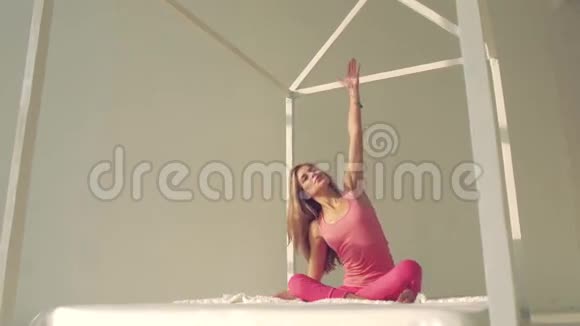 皮肤白皙的瑜伽女人在床上做瑜伽视频的预览图