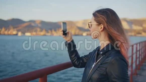 在智能手机上拍摄美丽海景的女人视频的预览图