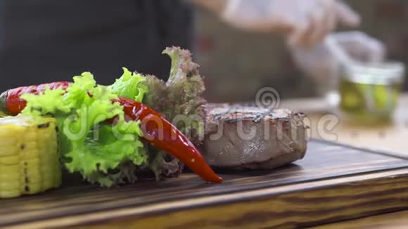 烧烤肉排组成用红辣椒香草玉米和番茄酱在木板上烤牛排食物视频的预览图