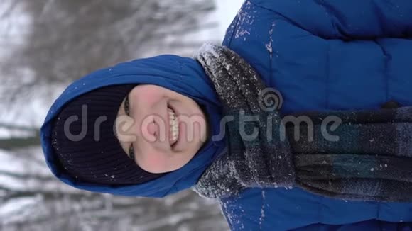 冬天森林里一个年轻人的肖像大雪纷飞视频的预览图