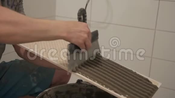 在浴室工作的工人手的特写正在修理瓷砖视频的预览图
