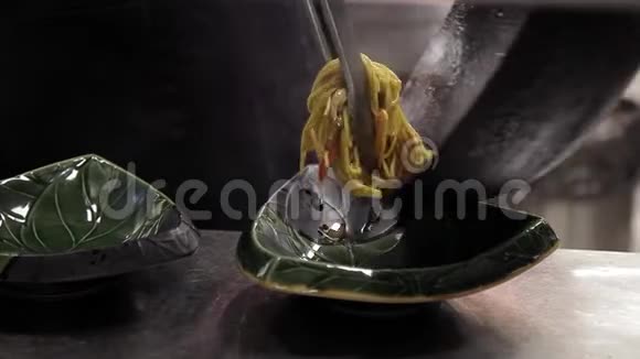 男人的厨师把意大利面和蔬菜和肉放在室内的盘子里视频的预览图