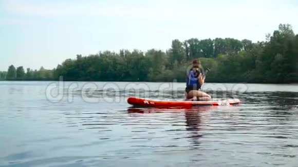 美丽的少女漂浮在河上的皮艇上视频的预览图