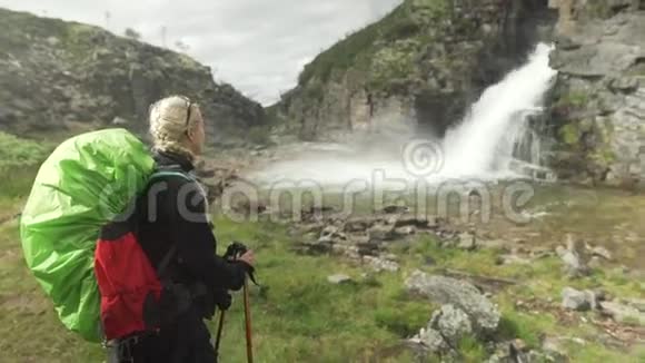 挪威Rondane国家公园欣赏瀑布的女人视频的预览图