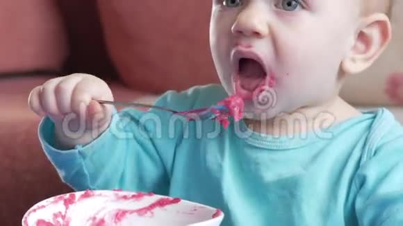一个2岁有魅力的男孩吃一份红甜菜沙拉面涂抹粥放在桌子上视频的预览图
