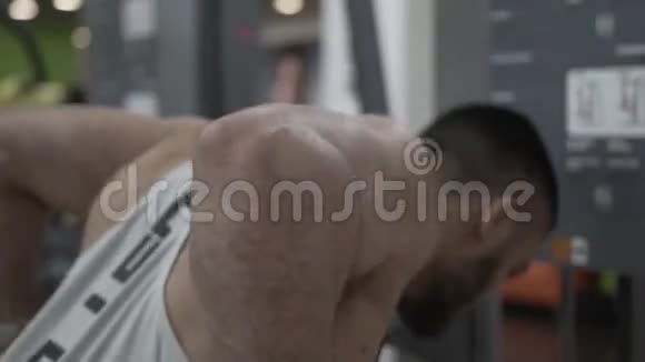肌肉男在健身房双杠上做三头肌锻炼的特写镜头视频的预览图