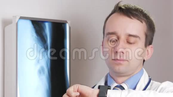 一位年轻的医生在诊所里用一只智能手表这个人告诉病人x光结果视频的预览图