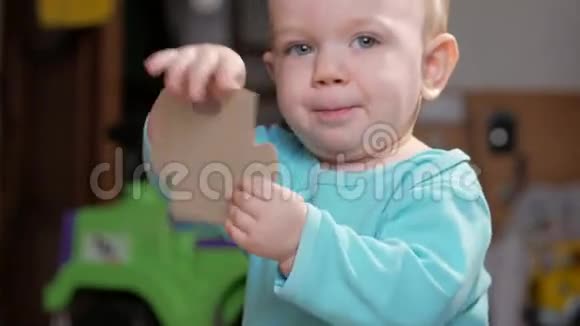 一个有魅力的男孩2岁拿起一个大拼图他拿着并看着图片的个别部分视频的预览图