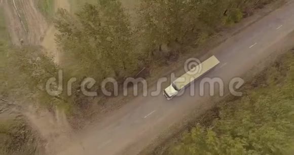 卡车在马路上穿过树木的小巷视频的预览图