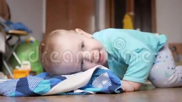 一个2岁的迷人男孩躺在地板上穿着衣服他在家玩完后休息视频的预览图