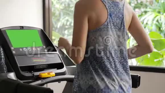 漂亮的运动女孩在运动健身房的跑步机上跑步慢动作3840x2160视频的预览图