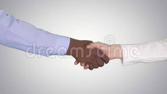 美国黑人和白种人女性在梯度背景下握手视频的预览图