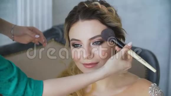 化妆师用画笔特写画女孩的眼睛视频的预览图