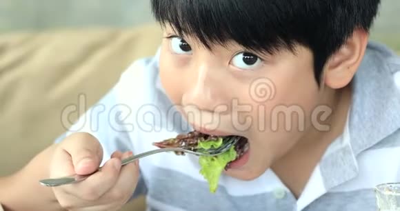 快乐的亚洲孩子喜欢吃美味的沙拉视频的预览图