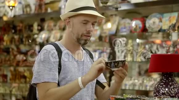 东方纪念品店里的男人留胡子戴帽子的人从东方之旅中挑选纪念品视频的预览图