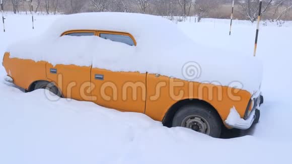 被雪覆盖的汽车在严重的冬季风暴下在雪下的院子里视频的预览图