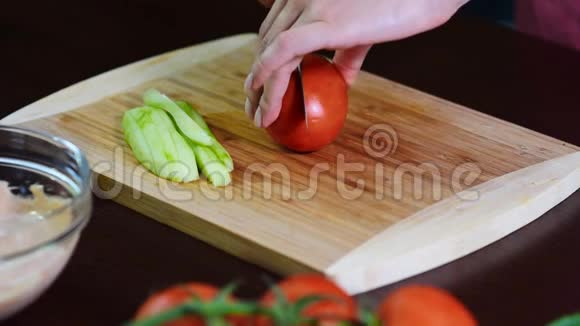 年轻女子在厨房切西红柿做新鲜沙拉视频的预览图