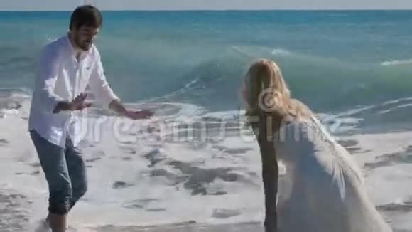 新婚夫妇在海洋中嬉戏玩耍视频的预览图