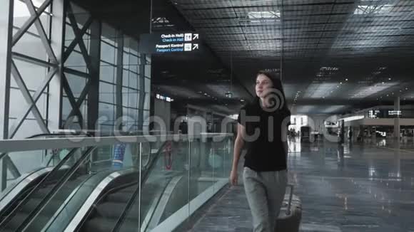 年轻漂亮的商务女性在机场边走边带着行李等待登记旅行视频的预览图