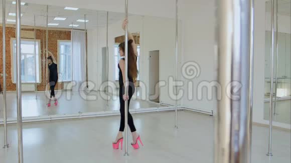 灵活的体操运动员在一个工作室里展示她在塔架上的缠绕视频的预览图