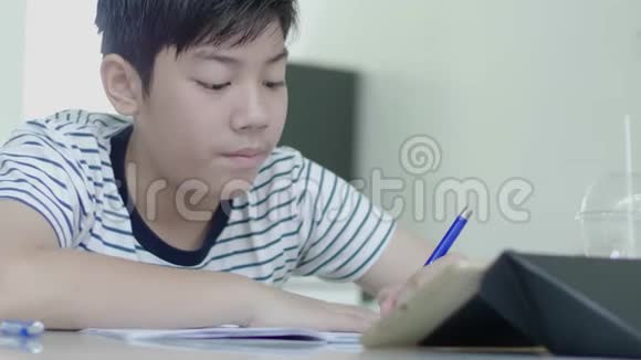 亚洲男孩用平板电脑找到答案视频的预览图