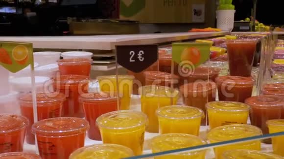 在商店橱窗的塑料容器中新鲜挤压果汁拉波奎利亚巴塞罗那西班牙视频的预览图