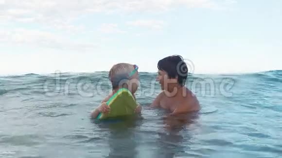 小男孩试图用游泳板慢动作捕捉波浪视频的预览图