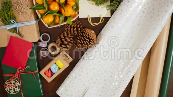 4K女手切割包纸盒与圣诞礼物的俯视图视频的预览图