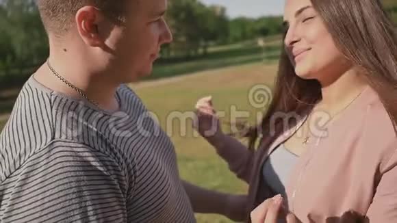 一对浪漫的情侣在绿色的夏天公园里他们用爱拥抱彼此一起快乐视频的预览图