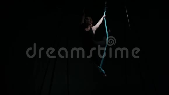 一个年轻女孩挂在吊床上做空中瑜伽视频的预览图