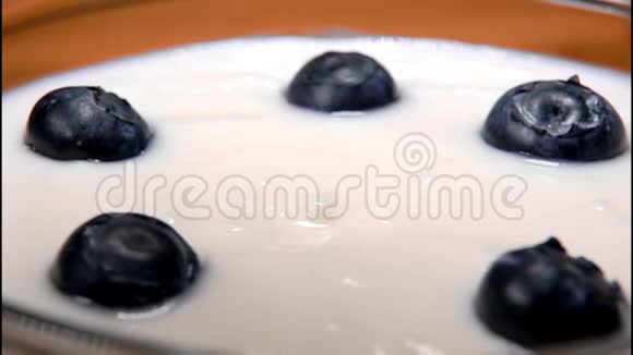 蓝莓和酸奶一起掉进玻璃碗里视频的预览图